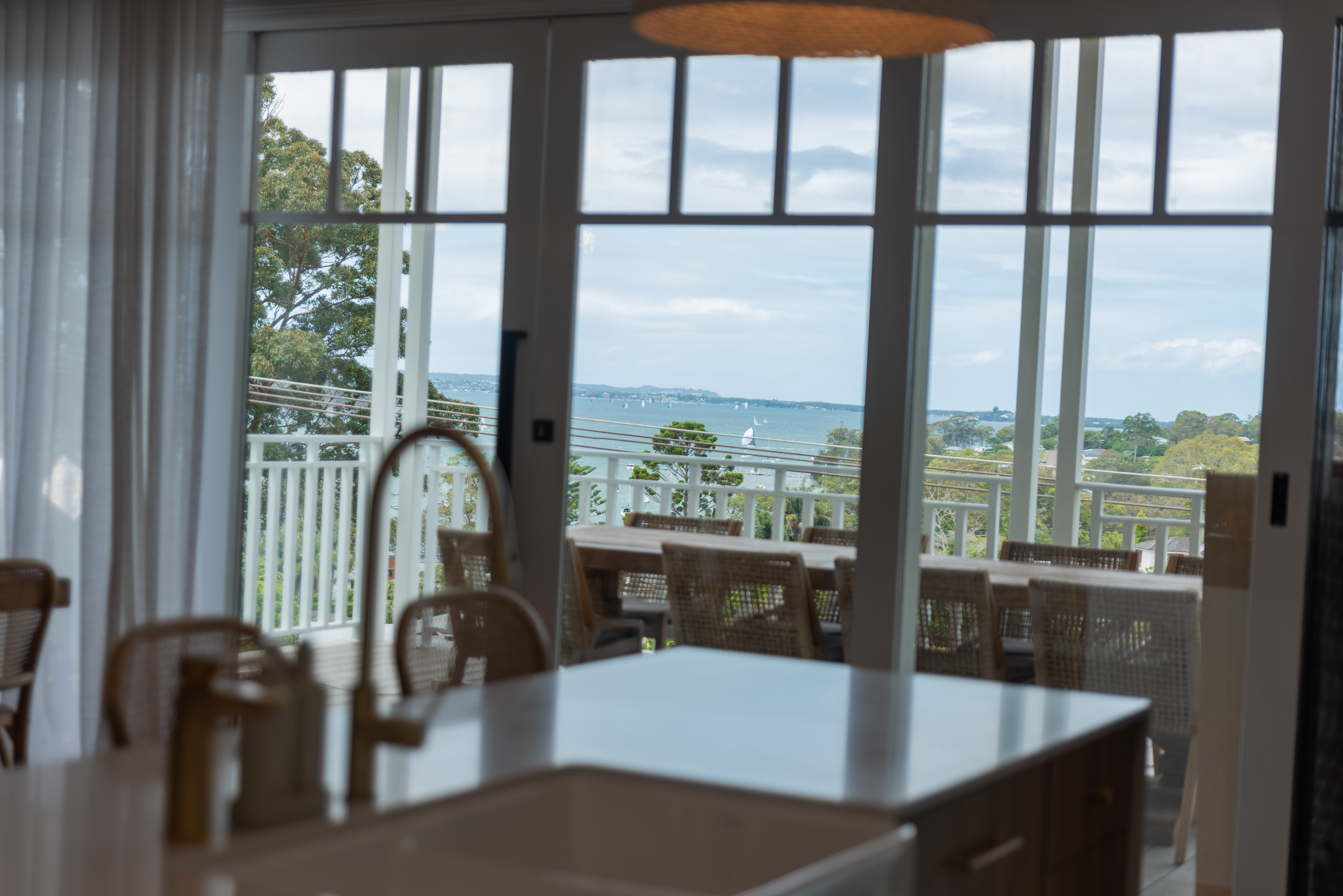Wangi Wangi House kitchen opening to the deck and Lake Macquarie view
